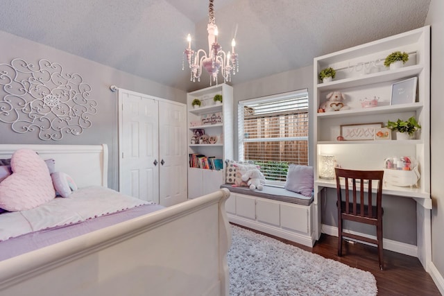 bedroom with a textured ceiling, a chandelier, dark wood-style flooring, and lofted ceiling