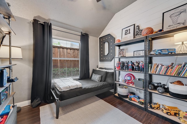 bedroom with vaulted ceiling, baseboards, and wood finished floors