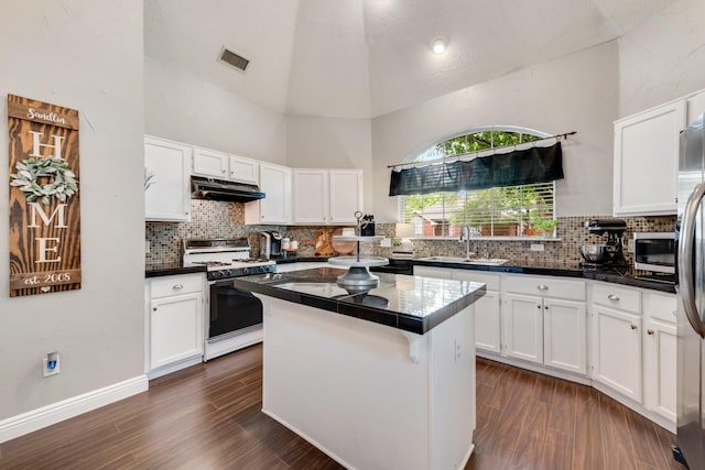 kitchen with a sink, white cabinetry, visible vents, under cabinet range hood, and appliances with stainless steel finishes