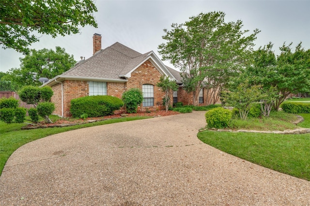 908 Willow Brook Dr, Allen, TX 75002 - view of front facade with a chimney, roof with shingles, brick siding, a front lawn, and concrete driveway