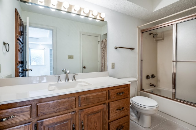 908 Willow Brook Dr, Allen, TX 75002 - bathroom featuring a textured ceiling, tile patterned flooring, vanity, toilet, and enclosed tub / shower combo