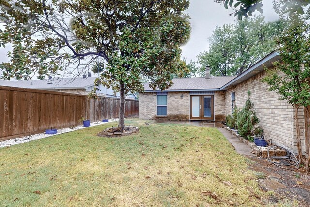 view of yard featuring french doors and a fenced backyard