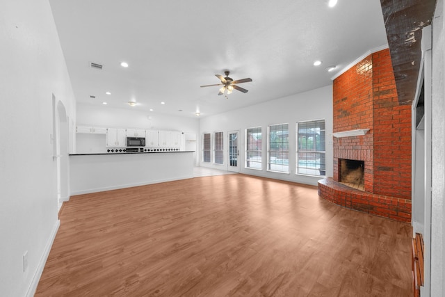 unfurnished living room featuring ceiling fan, a fireplace, recessed lighting, baseboards, and visible vents