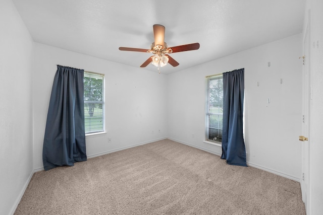 carpeted spare room with baseboards and ceiling fan
