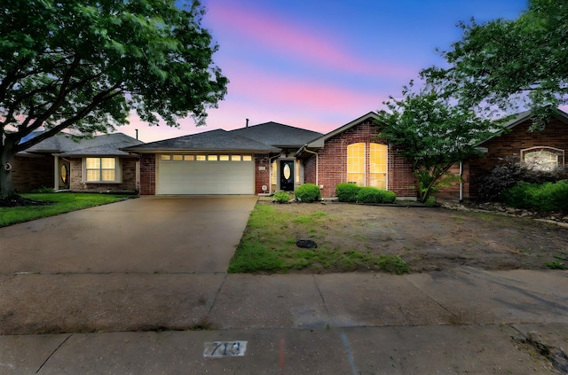 ranch-style house with brick siding, driveway, and a garage