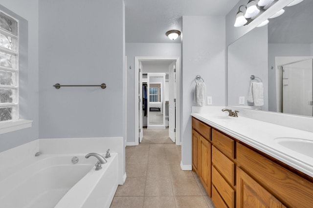 full bathroom featuring tile patterned flooring, a garden tub, double vanity, a sink, and a stall shower