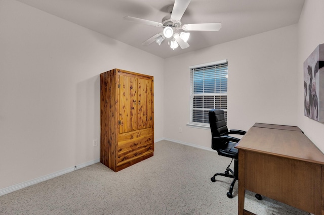 carpeted office with ceiling fan and baseboards