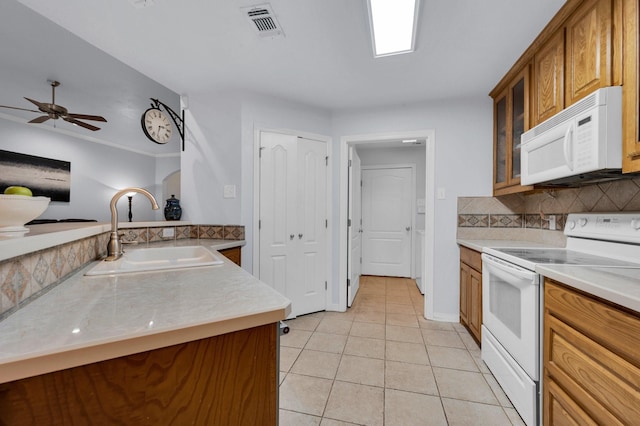 kitchen with light tile patterned flooring, a sink, white appliances, decorative backsplash, and visible vents