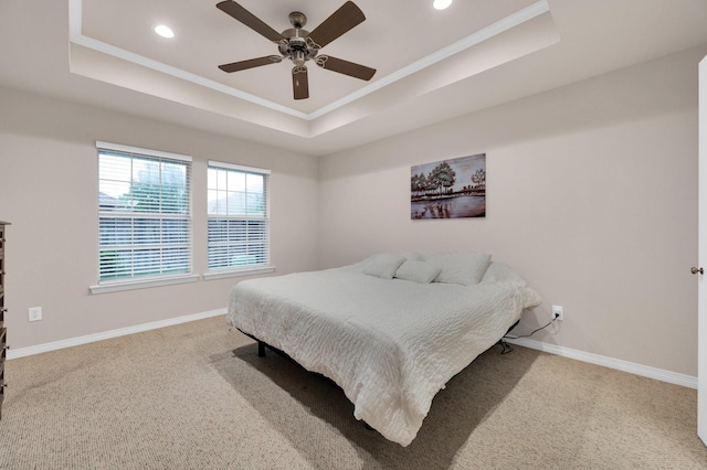 carpeted bedroom with crown molding, recessed lighting, baseboards, and a raised ceiling