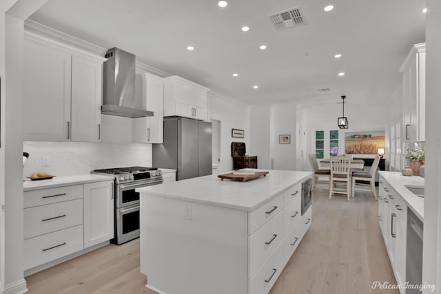 314 Gentilly Cir, Shreveport, LA 71106 - kitchen with wall chimney exhaust hood, stainless steel appliances, recessed lighting, a kitchen island, and visible vents