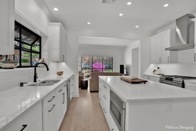 314 Gentilly Cir, Shreveport, LA 71106 - kitchen featuring wall chimney range hood, appliances with stainless steel finishes, a center island, a sink, and recessed lighting