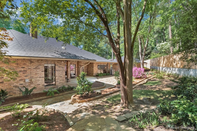 314 Gentilly Cir, Shreveport, LA 71106 - exterior space featuring fence, a patio, roof with shingles, and brick siding