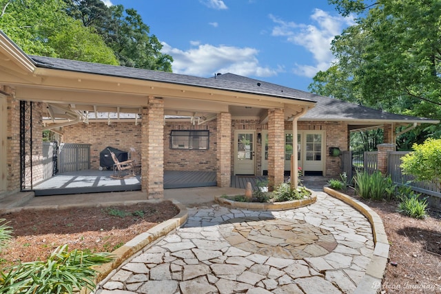 314 Gentilly Cir, Shreveport, LA 71106 - rear view of property featuring fence, a patio area, roof with shingles, and brick siding