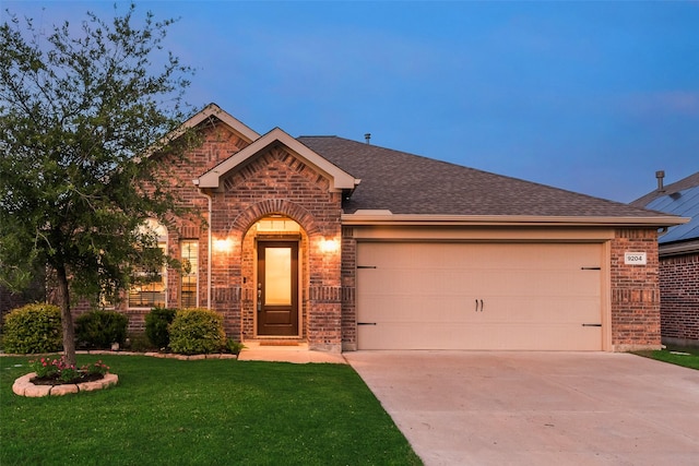 single story home featuring roof with shingles, a front yard, a garage, brick siding, and concrete driveway