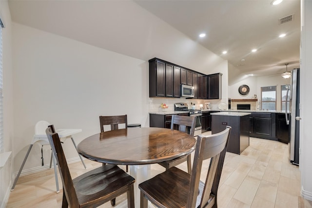 dining area featuring a ceiling fan, recessed lighting, lofted ceiling, light wood-type flooring, and visible vents