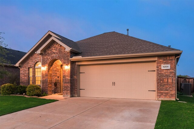ranch-style home with brick siding, an attached garage, driveway, and a front yard