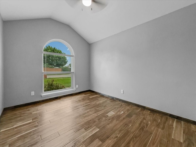 spare room with a ceiling fan, baseboards, wood finished floors, and lofted ceiling