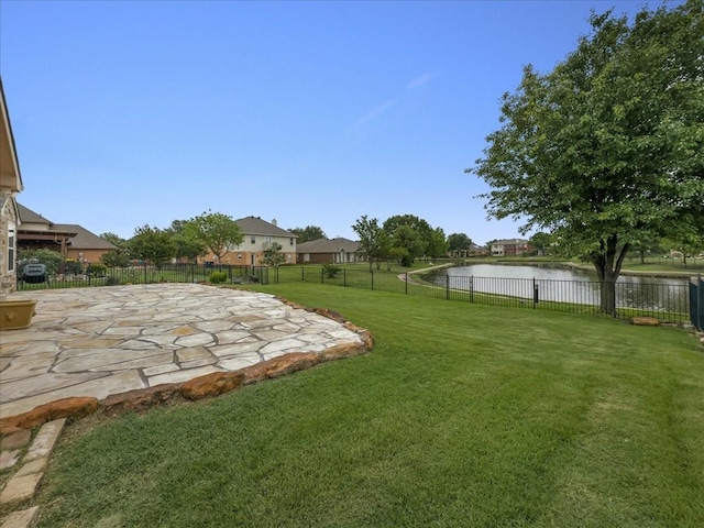view of yard featuring a water view, a patio area, and a fenced backyard