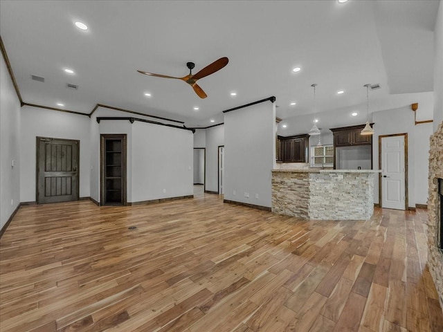 unfurnished living room featuring crown molding, a ceiling fan, baseboards, and light wood-style floors