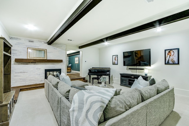 living area with baseboards, ornamental molding, beamed ceiling, and a large fireplace