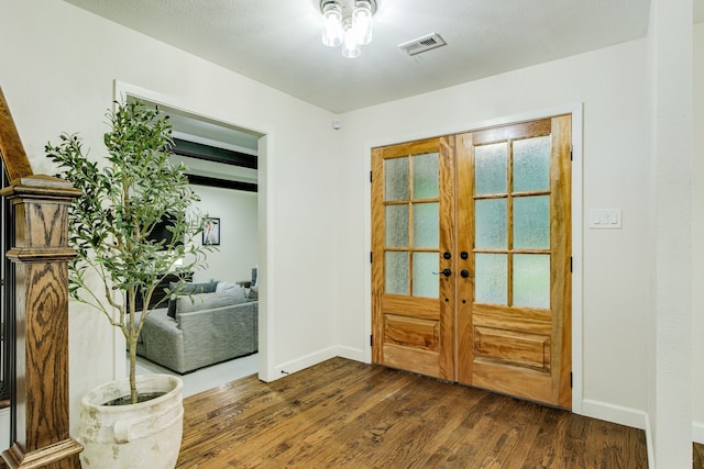 foyer featuring baseboards, visible vents, french doors, and dark wood-type flooring