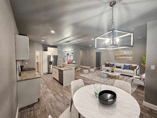 2120 Rw Bivens Ln, Fort Worth, TX 76105 - dining space with light wood-style floors, a chandelier, and recessed lighting