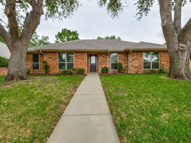 ranch-style home with brick siding and a front yard