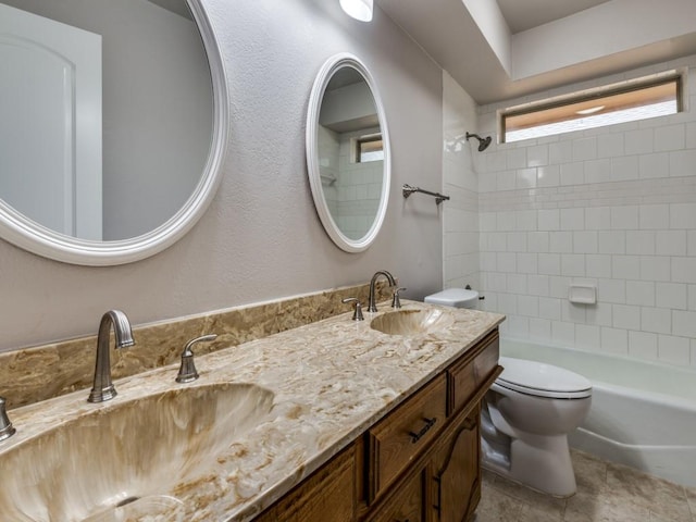 bathroom with double vanity, toilet, a sink, and bathtub / shower combination