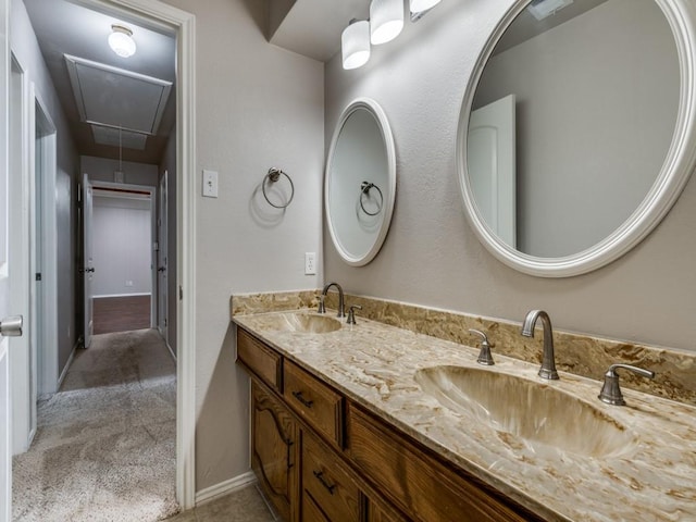 bathroom featuring a sink, baseboards, and double vanity
