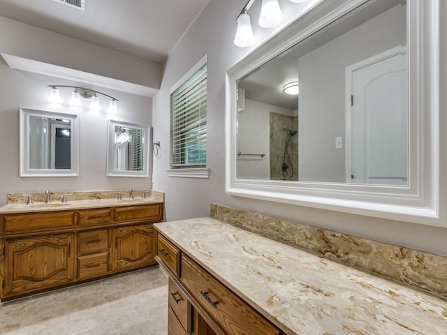 bathroom featuring double vanity, walk in shower, and a sink