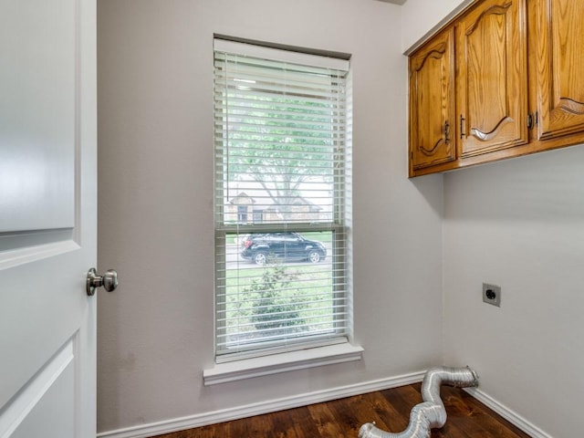 laundry room featuring cabinet space, electric dryer hookup, and wood finished floors