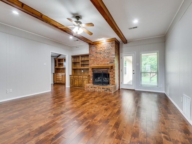 unfurnished living room with visible vents, beam ceiling, hardwood / wood-style floors, a fireplace, and ceiling fan