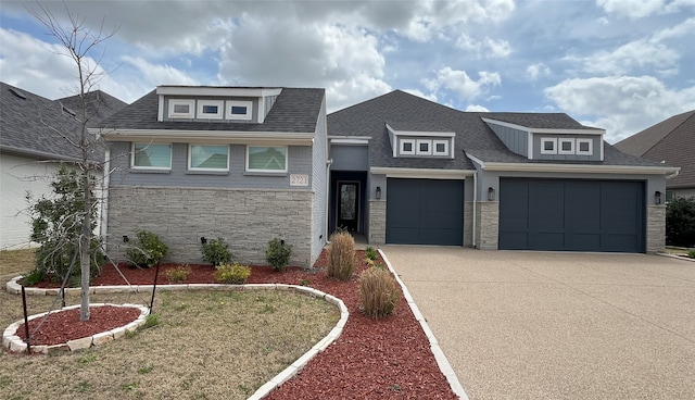 view of front of home with an attached garage, driveway, a shingled roof, and stone siding