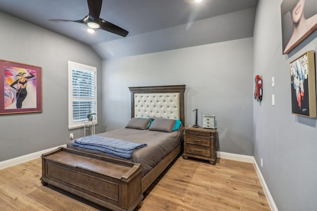 bedroom featuring baseboards, light wood-style flooring, ceiling fan, and vaulted ceiling