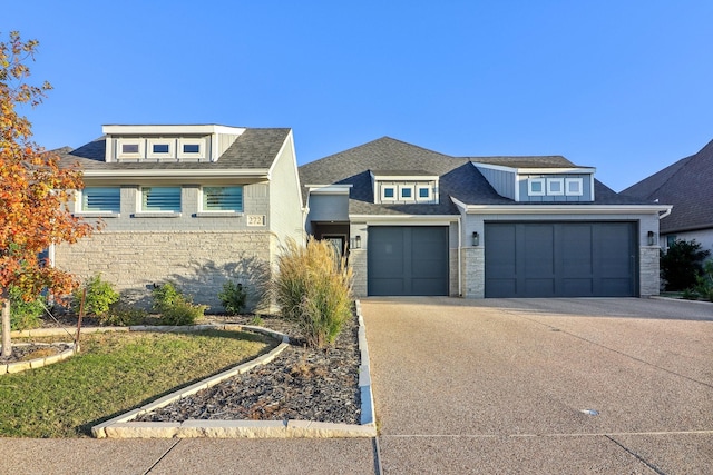 view of front of property with roof with shingles, an attached garage, driveway, and stone siding