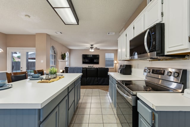 kitchen with plenty of natural light, appliances with stainless steel finishes, white cabinets, and open floor plan
