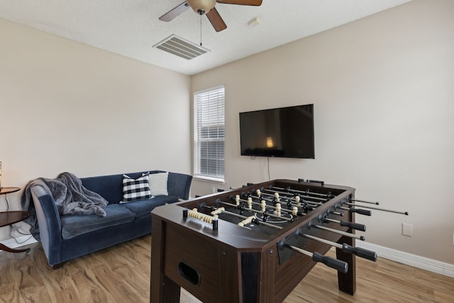 playroom featuring baseboards, ceiling fan, wood finished floors, and visible vents