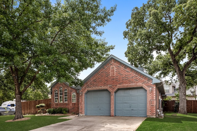 view of front of property with brick siding, an attached garage, driveway, and fence