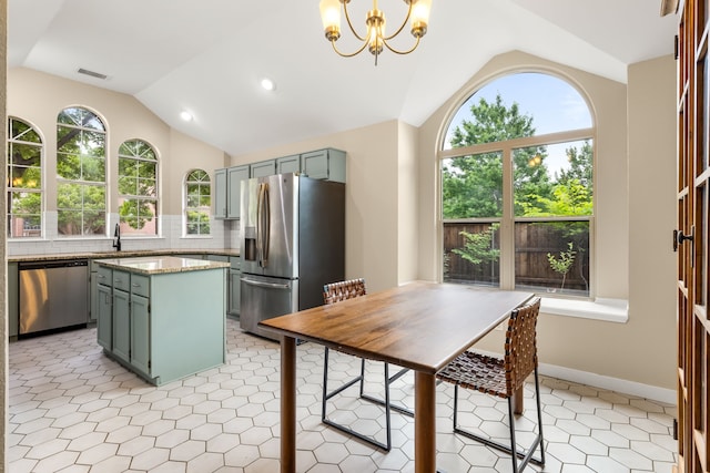 kitchen with appliances with stainless steel finishes, a sink, a chandelier, backsplash, and vaulted ceiling