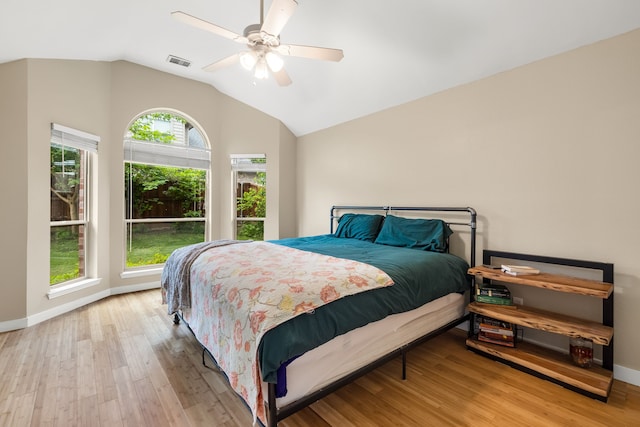 bedroom featuring ceiling fan, lofted ceiling, wood finished floors, and visible vents
