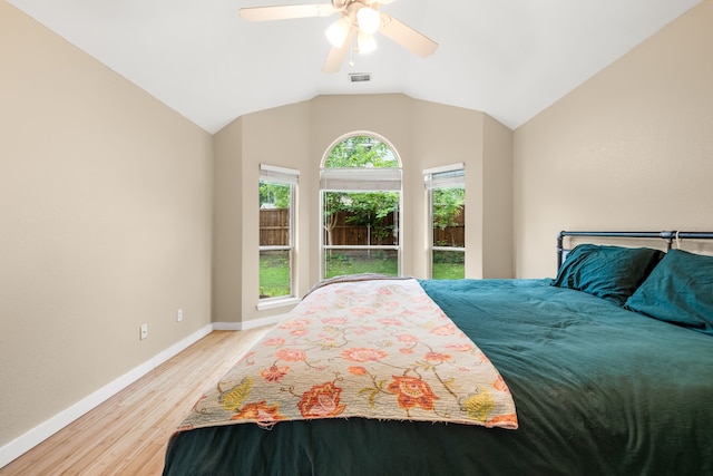 bedroom with visible vents, lofted ceiling, baseboards, a ceiling fan, and light wood finished floors