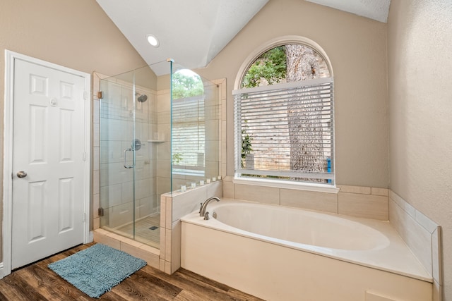 bathroom with vaulted ceiling, a shower stall, wood finished floors, and a bath