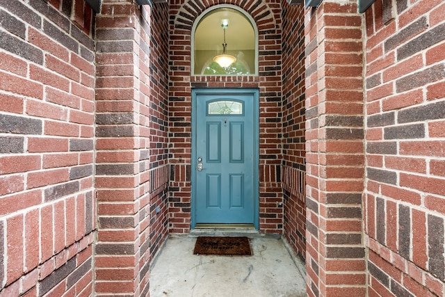 view of exterior entry featuring brick siding