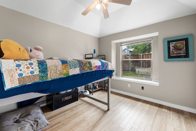 bedroom with baseboards, a ceiling fan, lofted ceiling, and wood finished floors