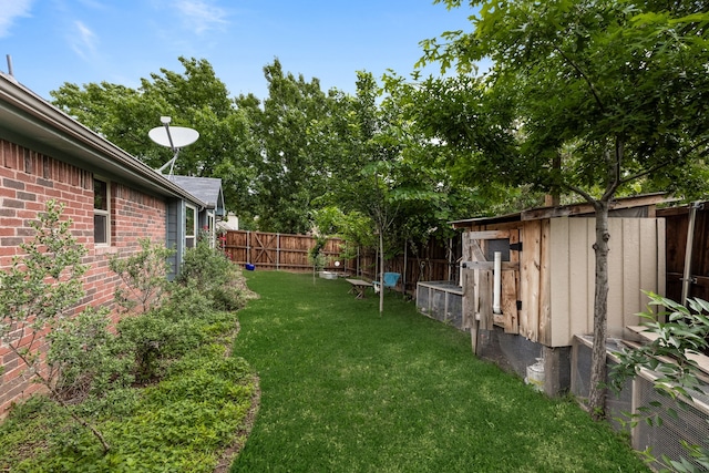 view of yard featuring a fenced backyard, an outbuilding, and a storage shed
