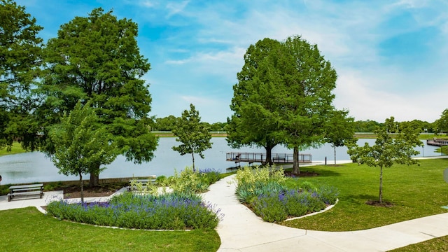 view of home's community with a lawn and a water view