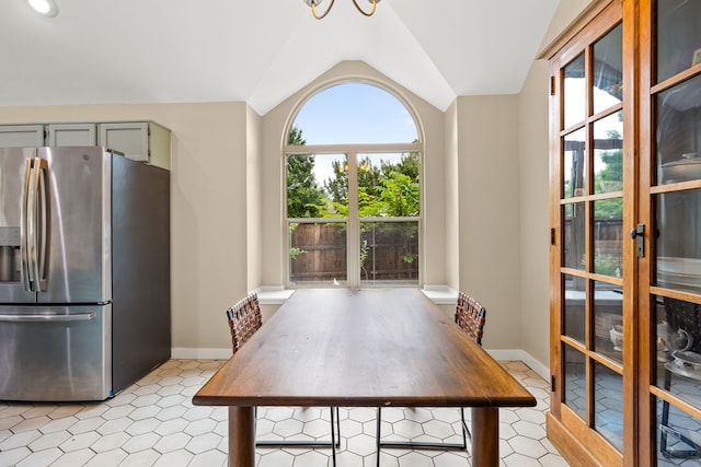 dining space with baseboards and vaulted ceiling