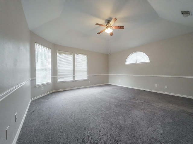 spare room with visible vents, baseboards, dark colored carpet, ceiling fan, and vaulted ceiling