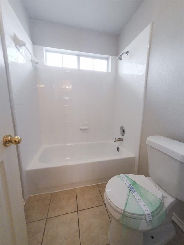 bathroom featuring tile patterned flooring, toilet, and tub / shower combination