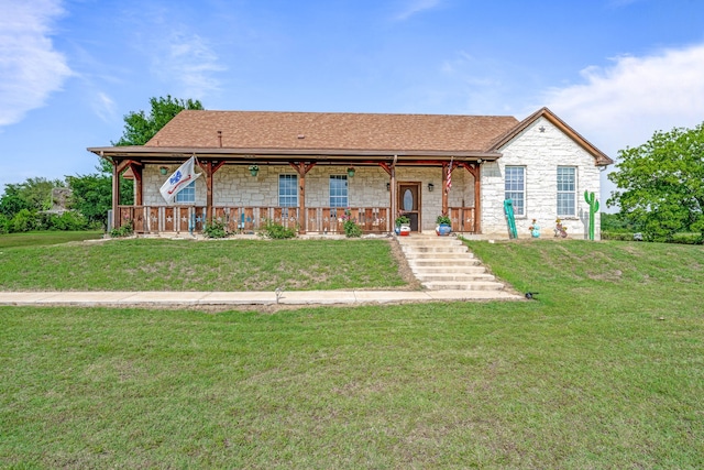 single story home with a porch, a shingled roof, stone siding, and a front lawn